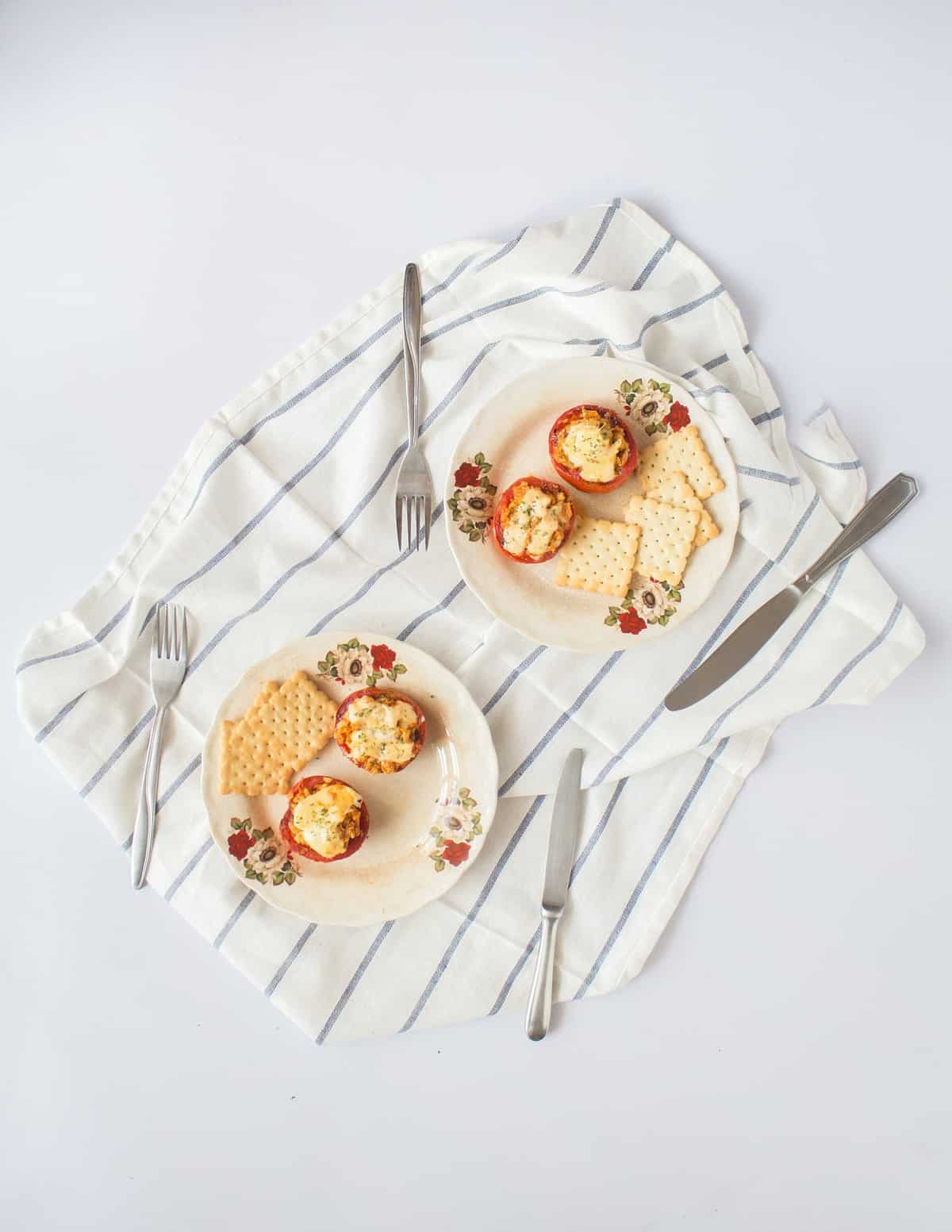 Two plates of snack on a cloth napkin with silverware.