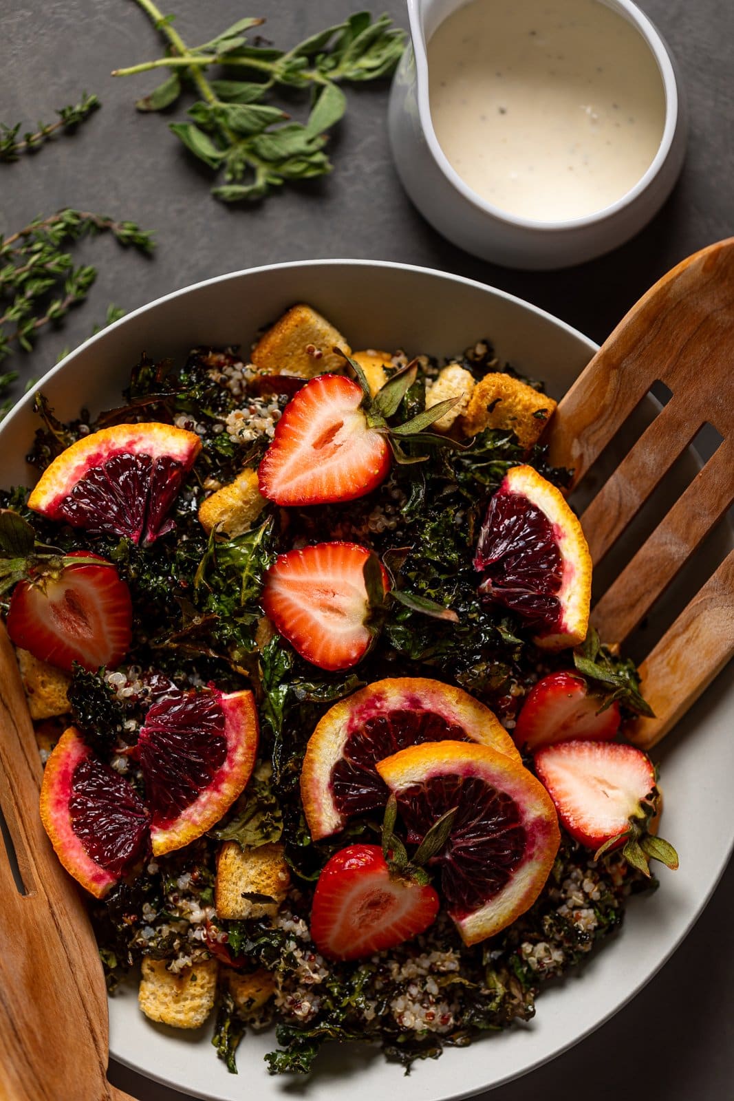 Salad tosser in a bowl of Blood Orange Kale Salad