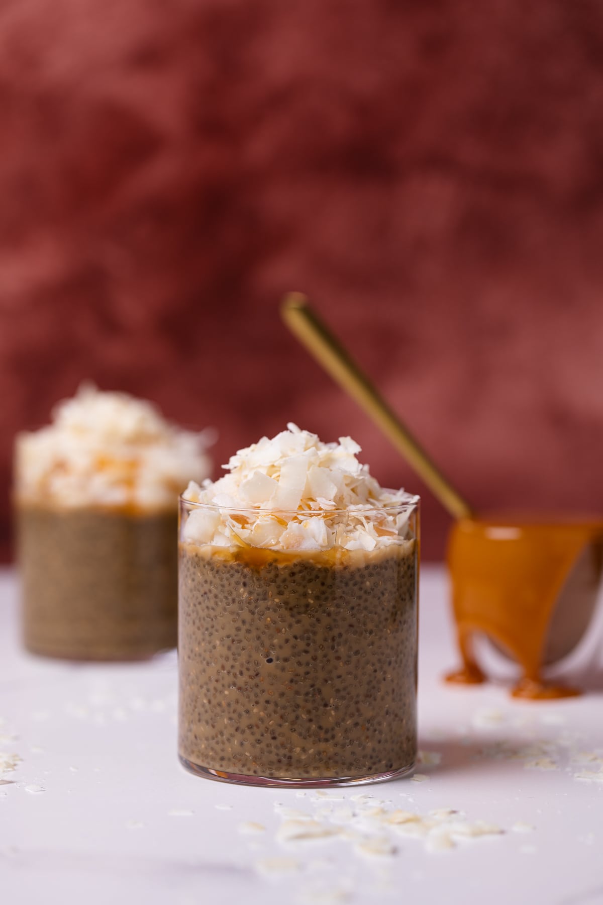 Two glass cups of Caramel Macchiato Chia Pudding topped with Coconut.