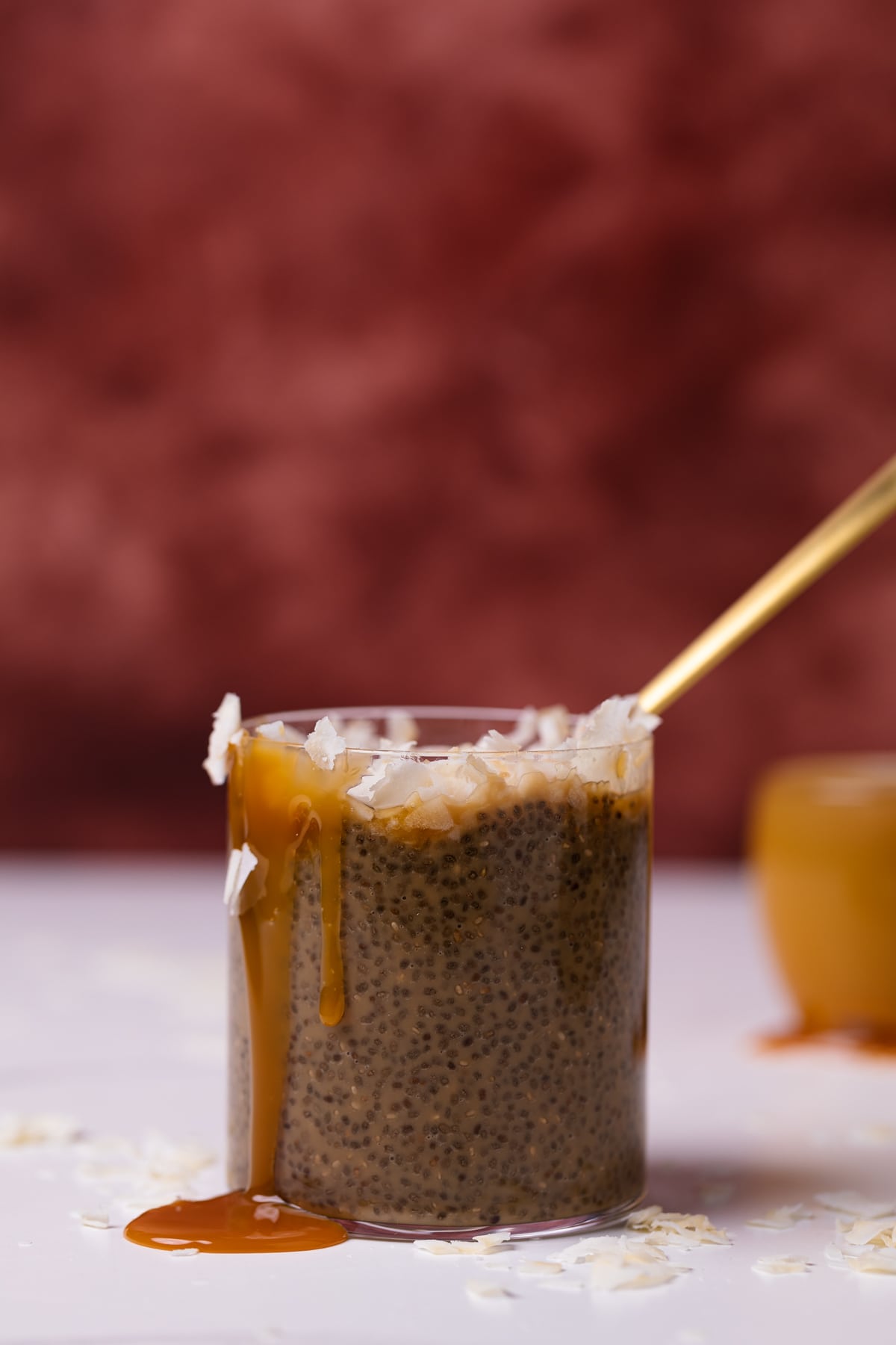 Spoon in a glass of Caramel Macchiato with homemade caramel sauce on the side.