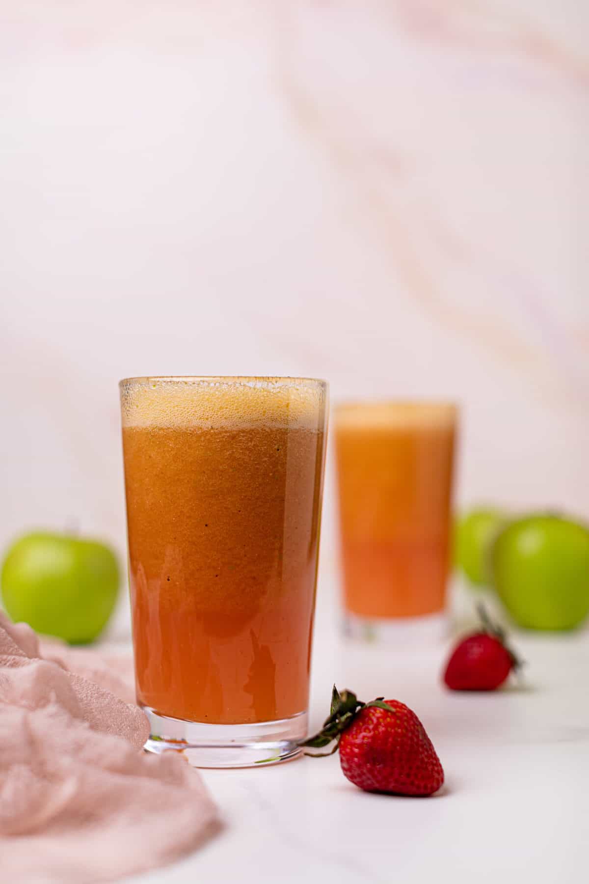 Apple Citrus Strawberry Juice in two glasses with strawberries.