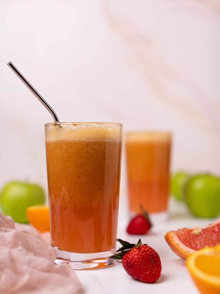 Metal straw in a glass of Apple Citrus Strawberry Juice.
