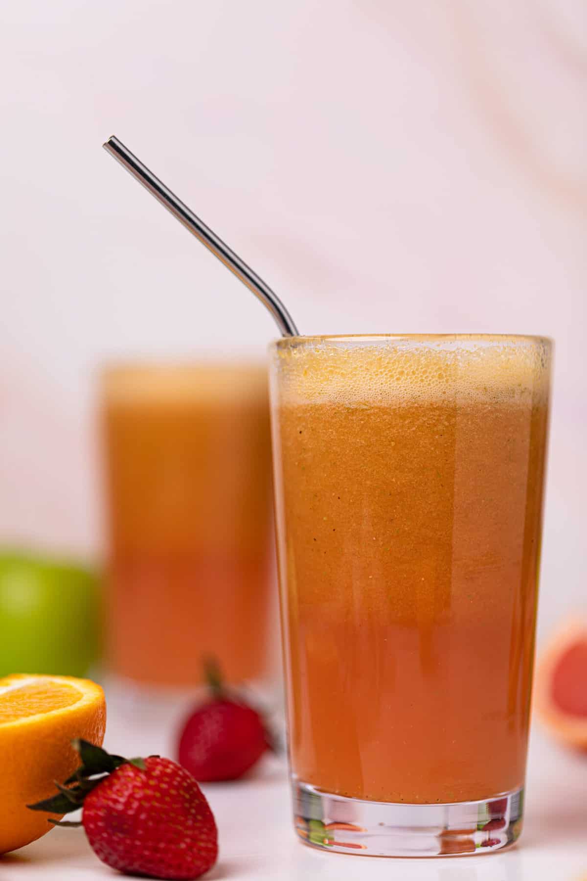 Apple Citrus Strawberry Juice in two glasses with a metal straw