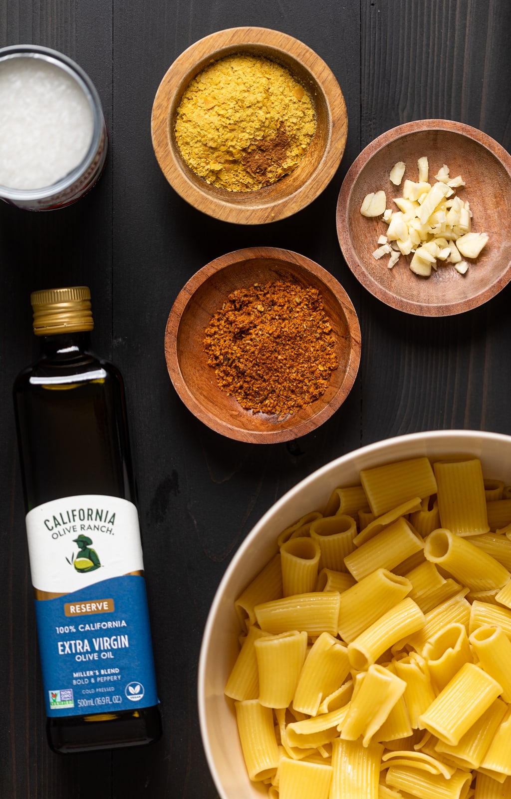 Ingredients on a table including olive oil, pasta, and garlic.