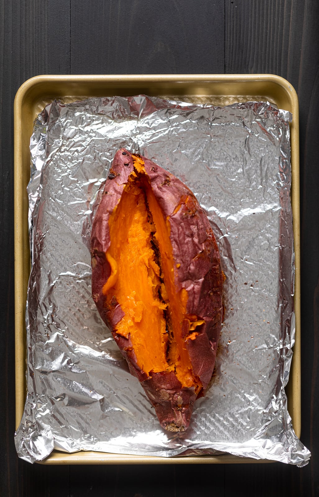 Cut, roasted sweet potato on a lined baking sheet.