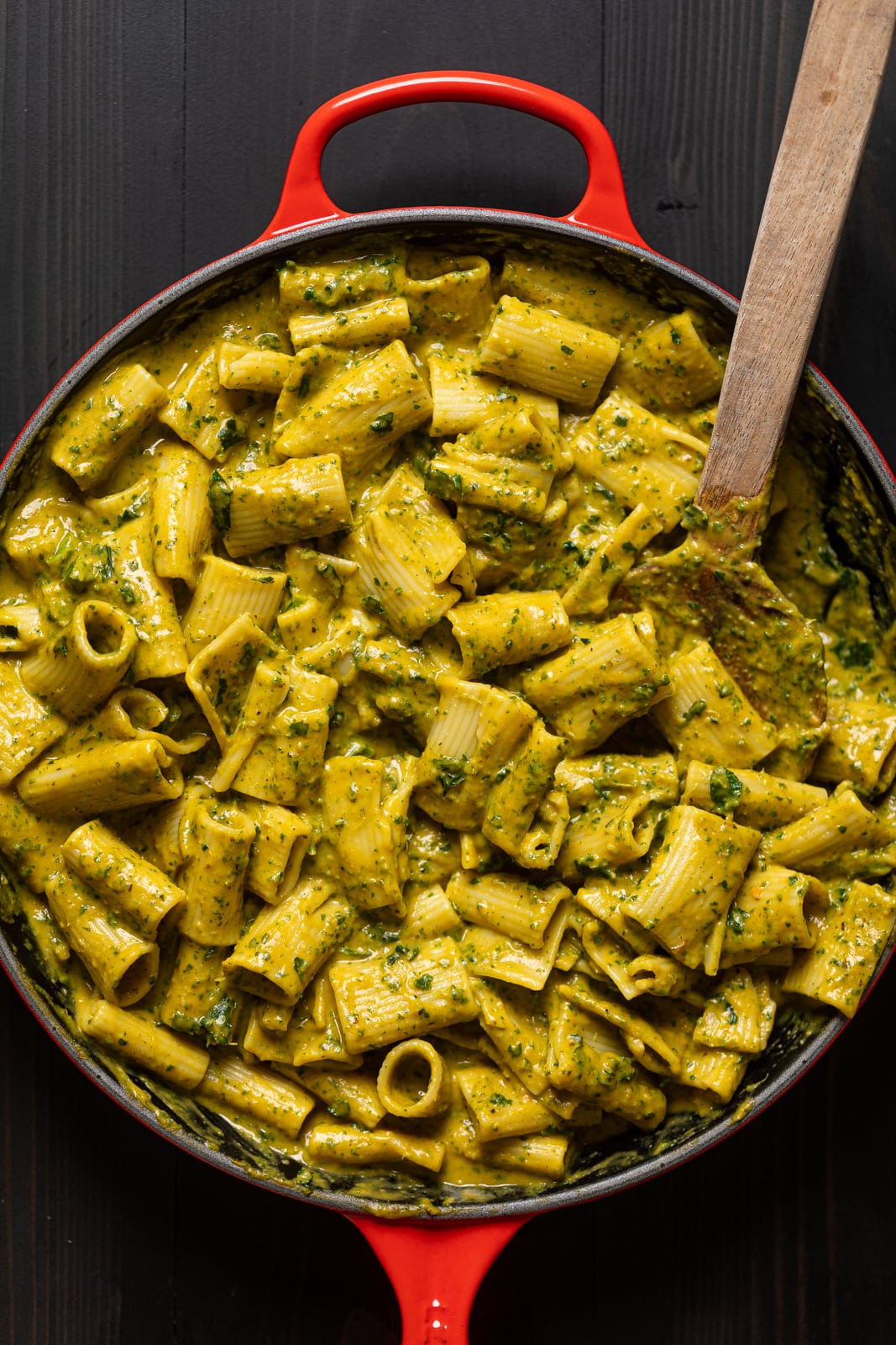 Wooden spoon stirring Creamy Vegan Sweet Potato Pasta.