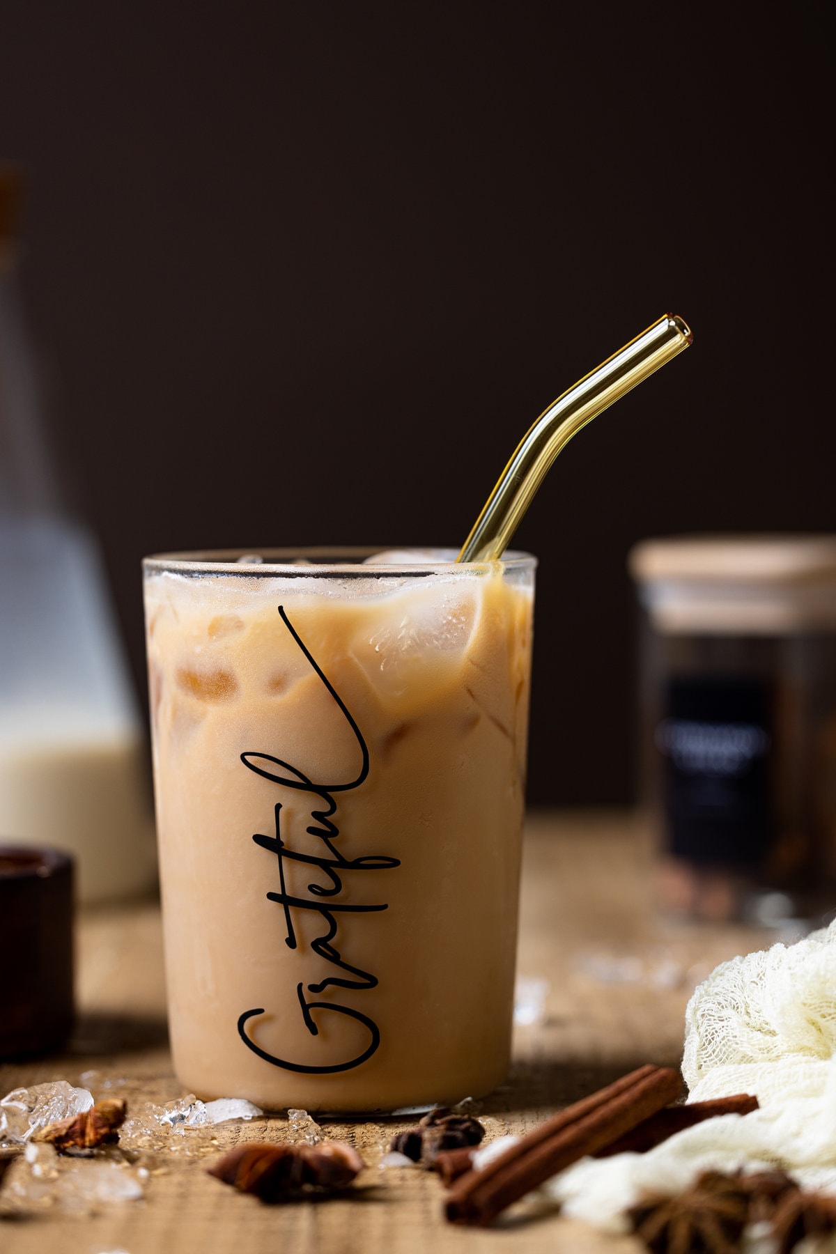 Iced Chai Tea Latte in a glass that reads \"Grateful\" with a straw