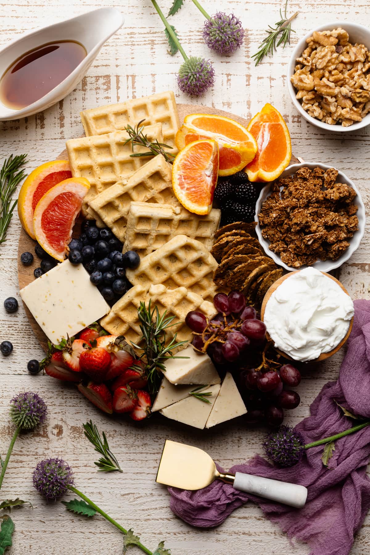 Wooden board stuffed with waffles, fruit, vegan cheese, and more.