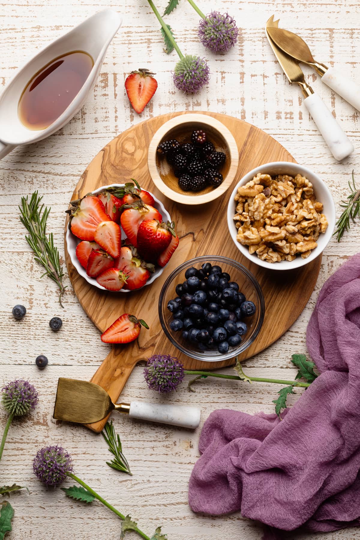 Bowls of fruits and nuts on a wooden board.