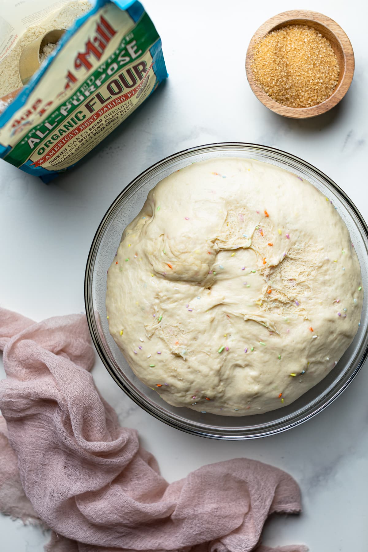 Risen dough in a glass bowl.