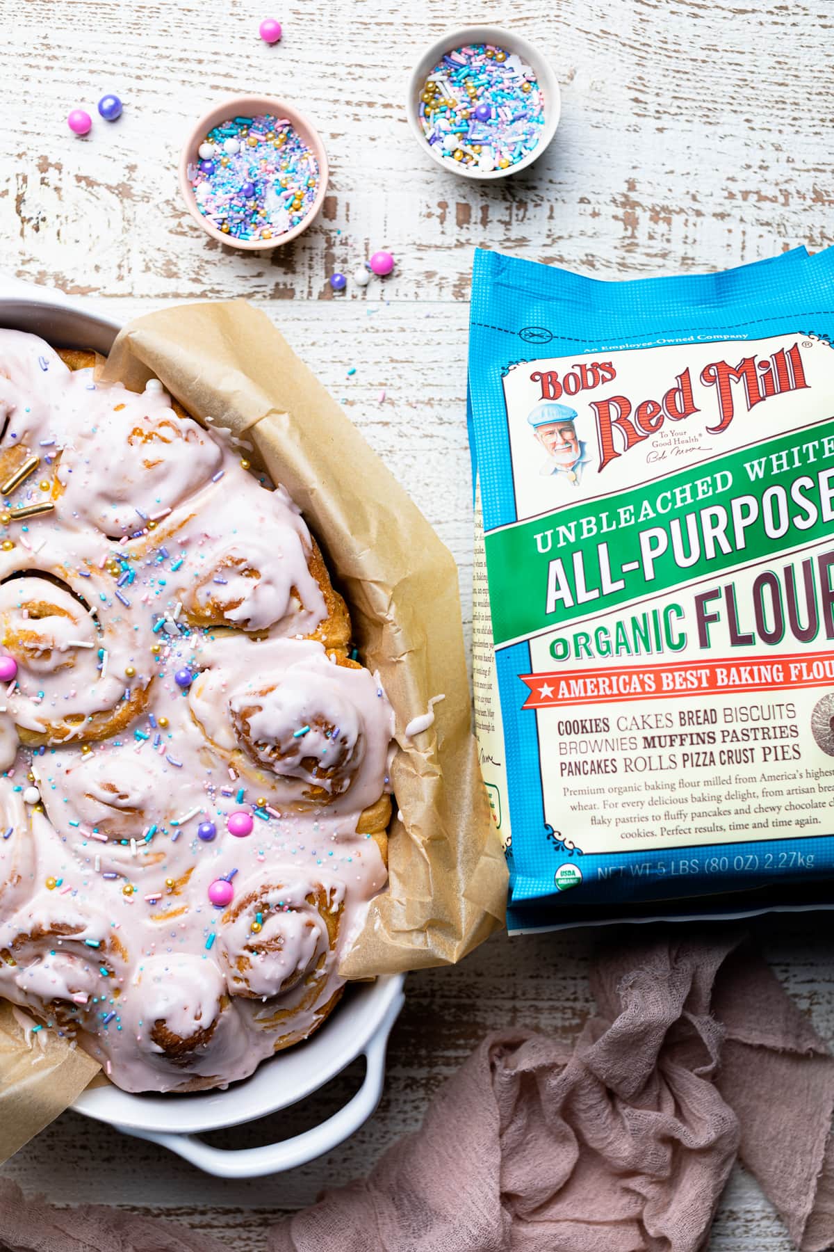 Vegan Funfetti Cinnamon Rolls next to a bag of Bob\'s Red Mill flour.