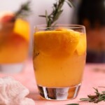 Grapefruit Apple Cider Vinegar drink with fresh rosemary in a glass.