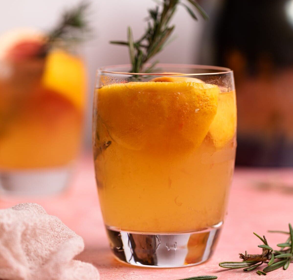 Grapefruit Apple Cider Vinegar drink with fresh rosemary in a glass.