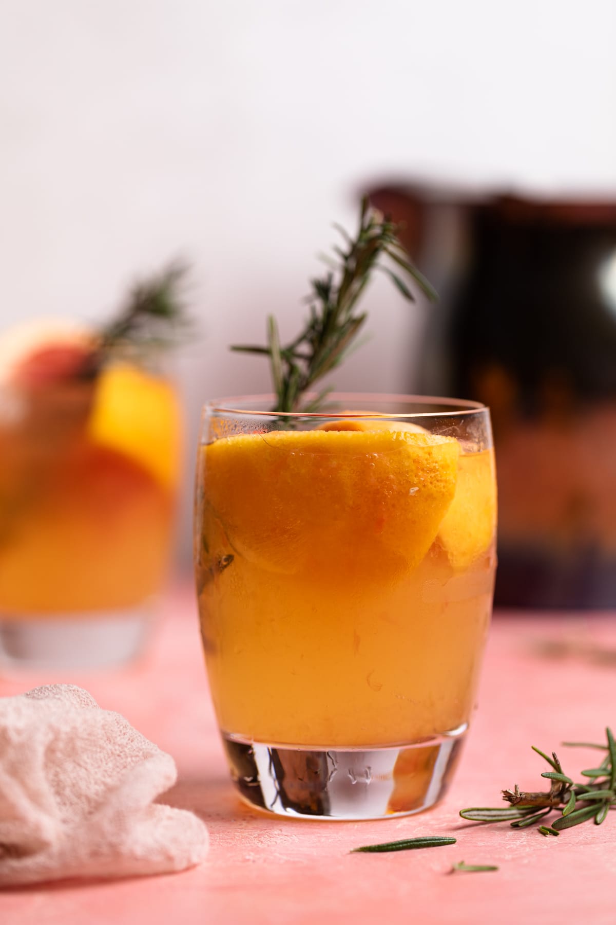 Grapefruit Apple Cider Vinegar drink with fresh rosemary in a glass.