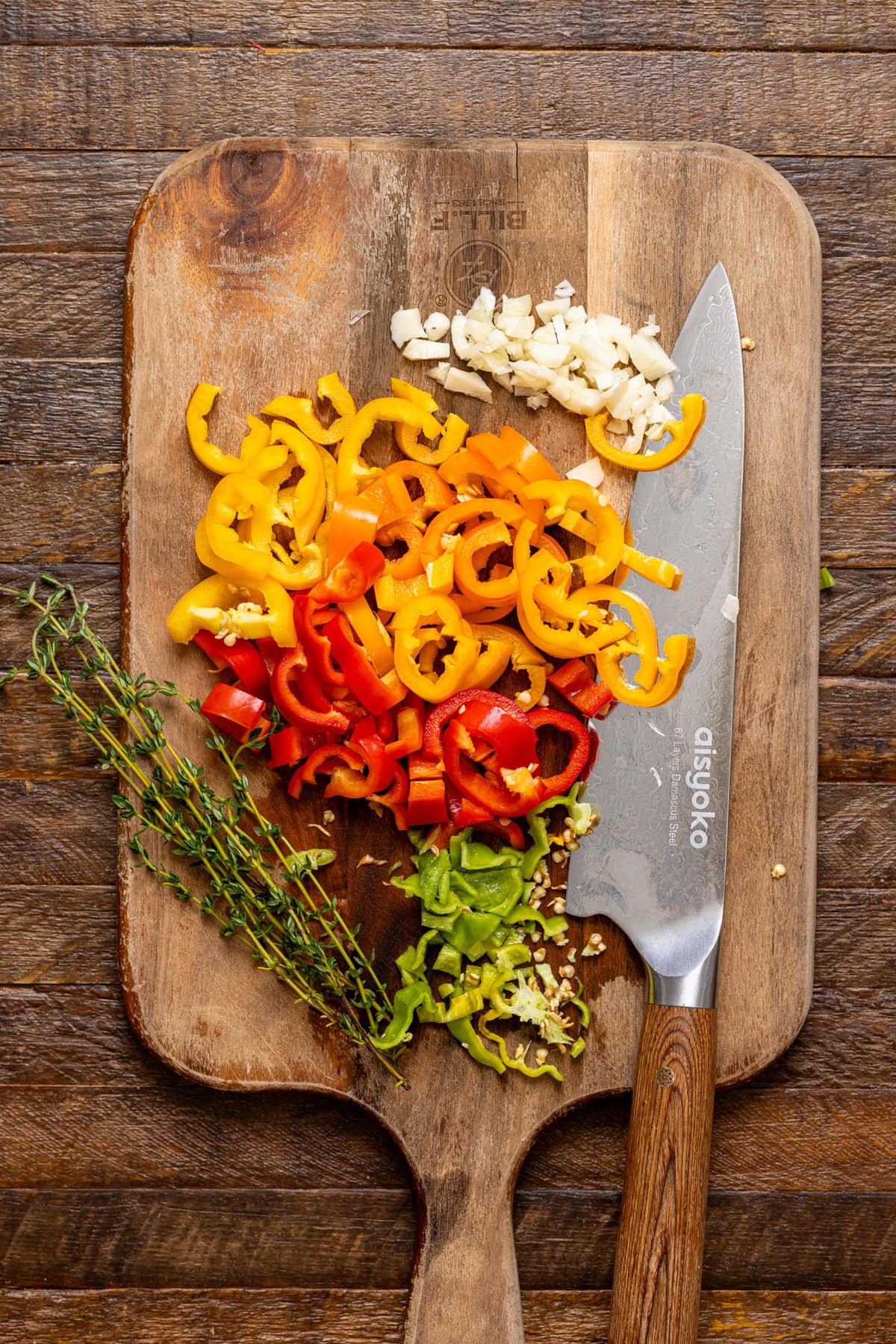 Veggies chopped on a cutting board with a knife. 