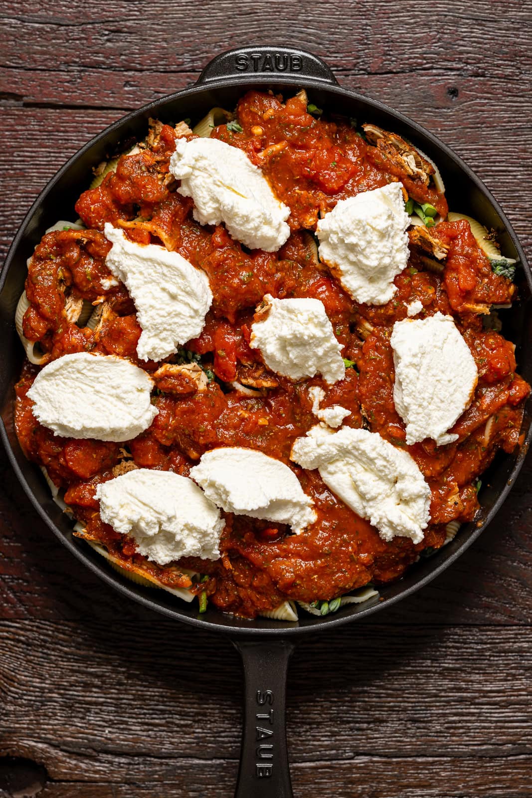 Ingredients assembled in a skillet on a brown wood table.
