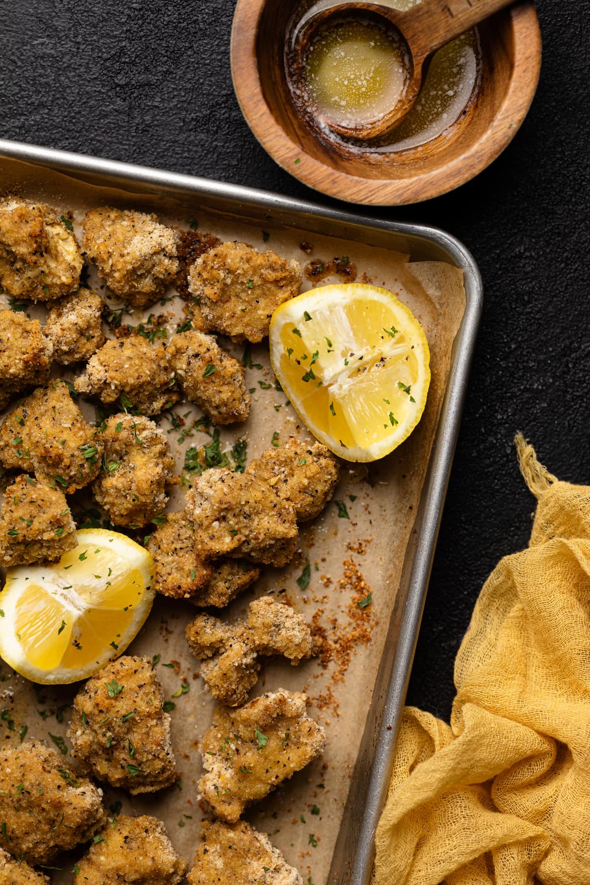 Lemon Pepper Cauliflower on a baking sheet with lemon wedges.