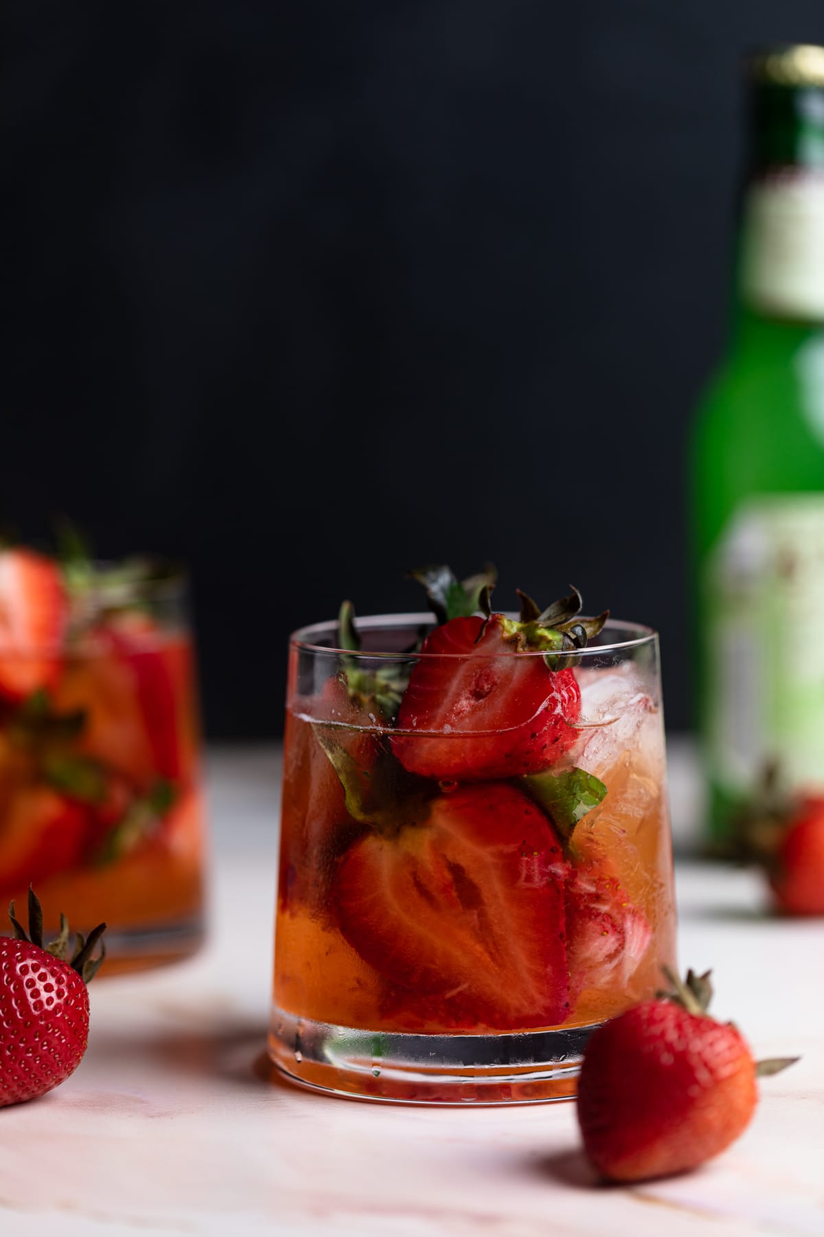 Strawberry Basil Pineapple Mocktail in a glass with fresh strawberries and basil.