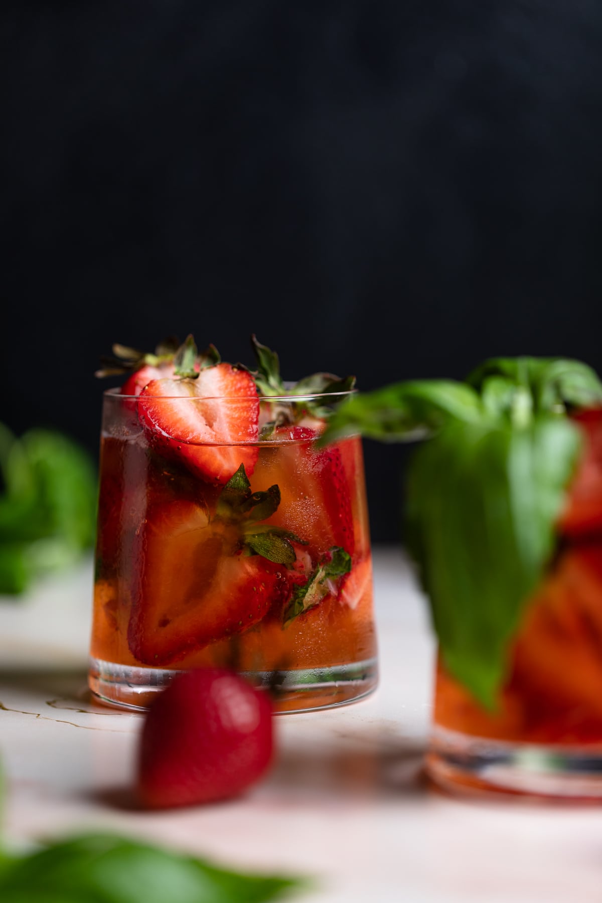 Strawberry Basil Pineapple Mocktail in a glass stuffed with fresh strawberries.