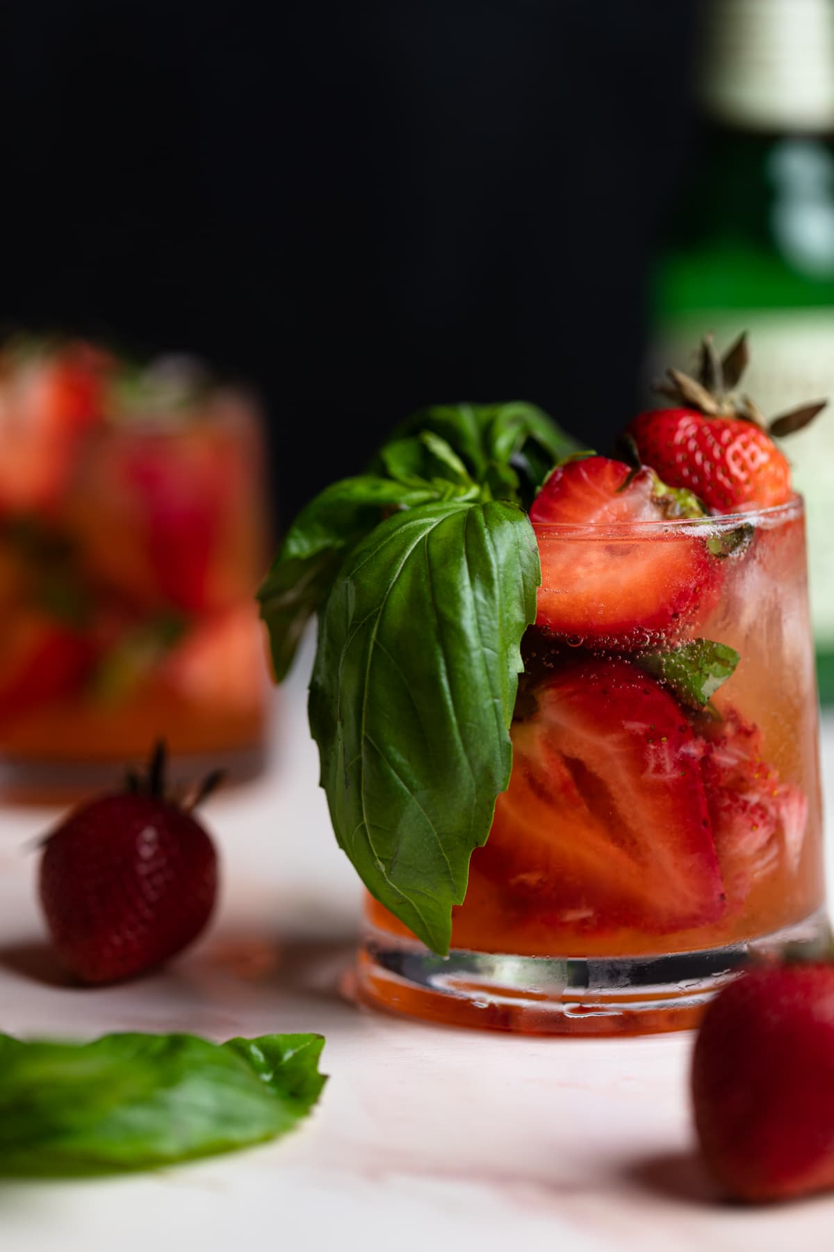 Strawberry Basil Pineapple Mocktail in a glass with fresh strawberries and basil