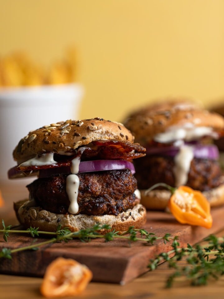 Barbeque Jerk Bacon Turkey Burgers lined on a wooden board.