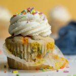 Vegan Funfetti Cupcake with the muffin paper partially removed.
