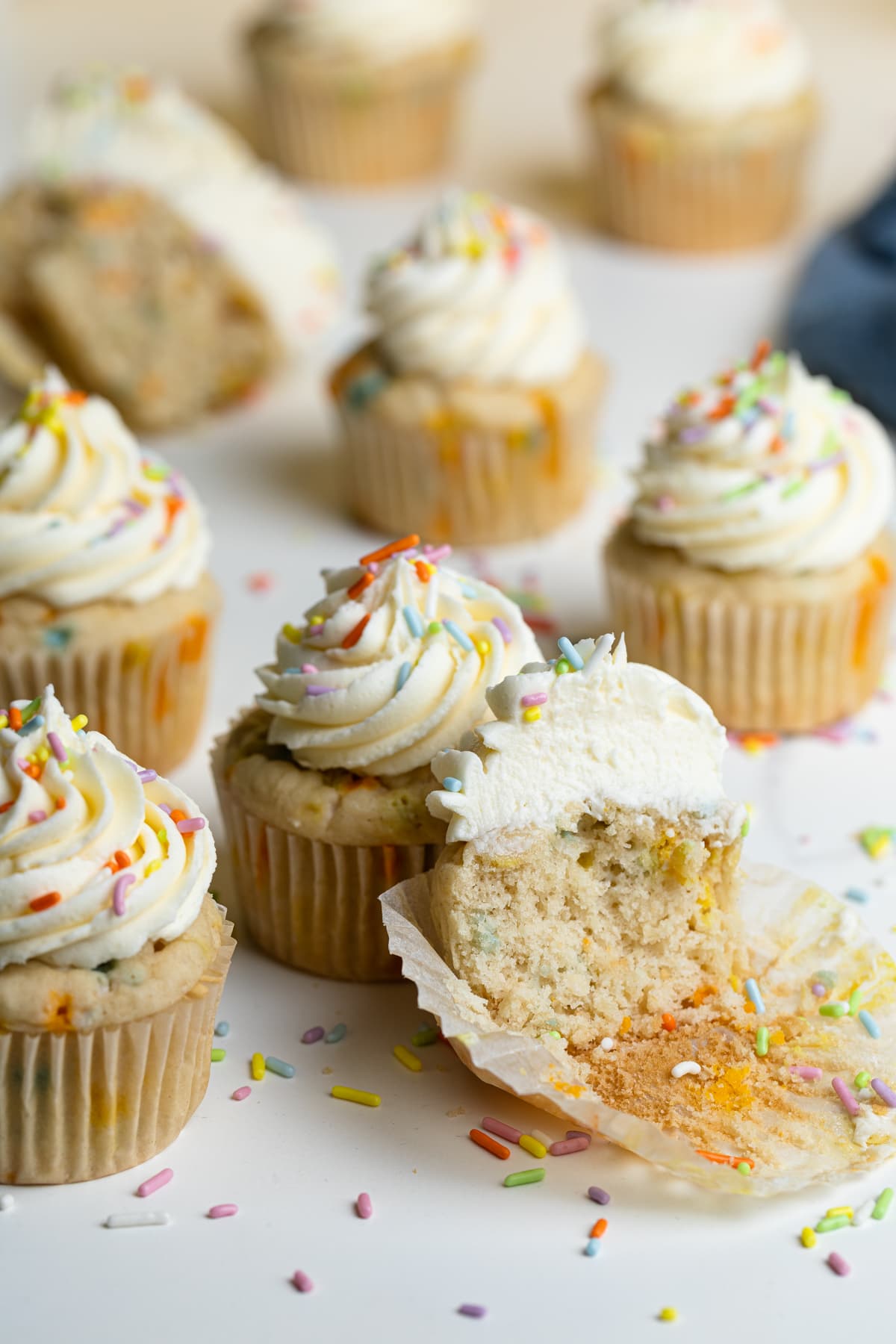 Vegan Funfetti Cupcakes on a table with sprinkles.