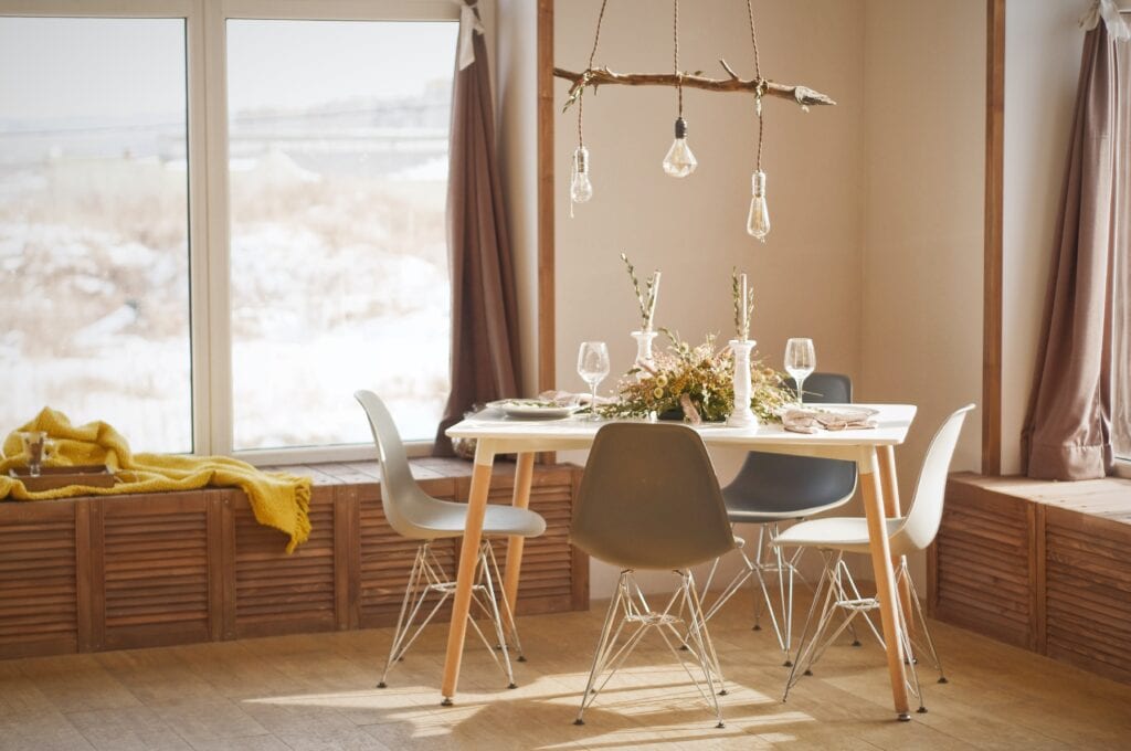 Light bulbs hanging from a wooden stick over a small table.