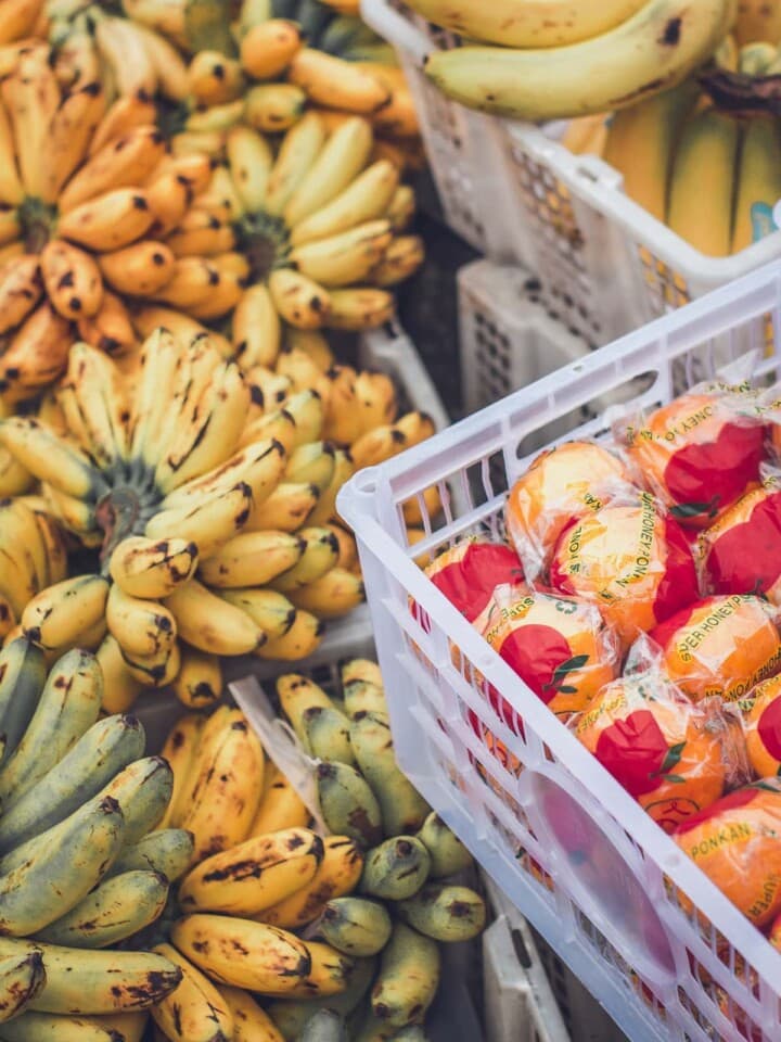 Bananas plus other fruits piled in a market.