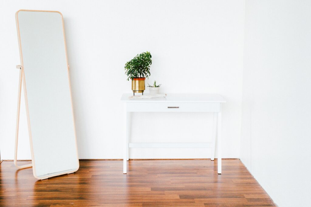 White end table on a brown wooden floor.