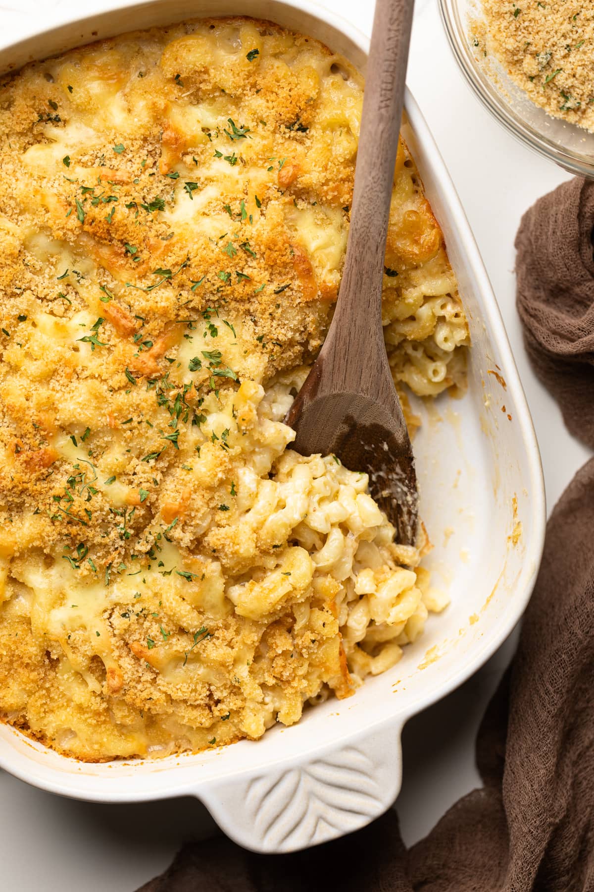 Wooden spoon scooping some Creamy Southern Baked Mac and Cheese