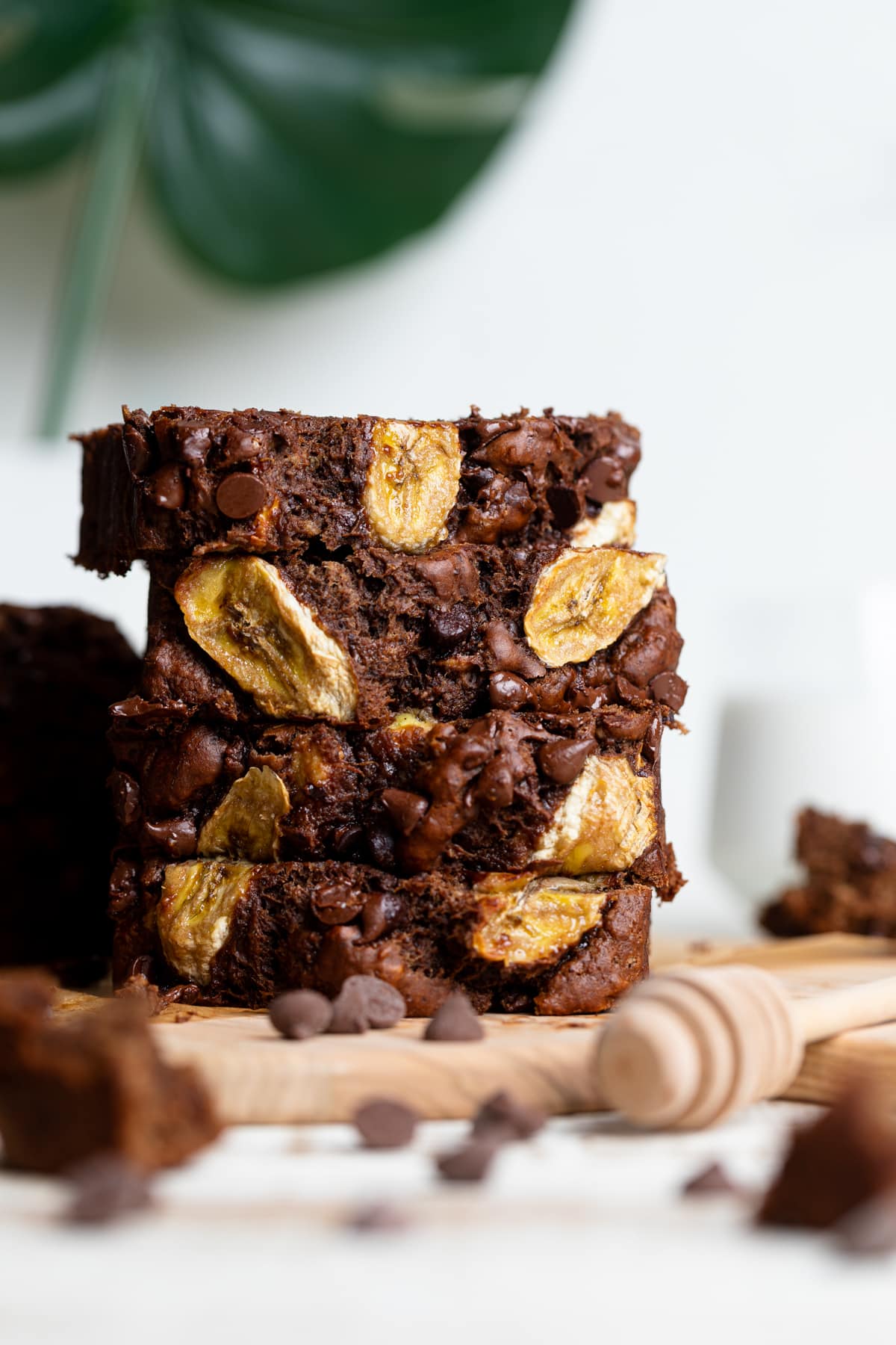 Slices of Vegan Chocolate Bourbon Banana Bread stacked on a wooden board