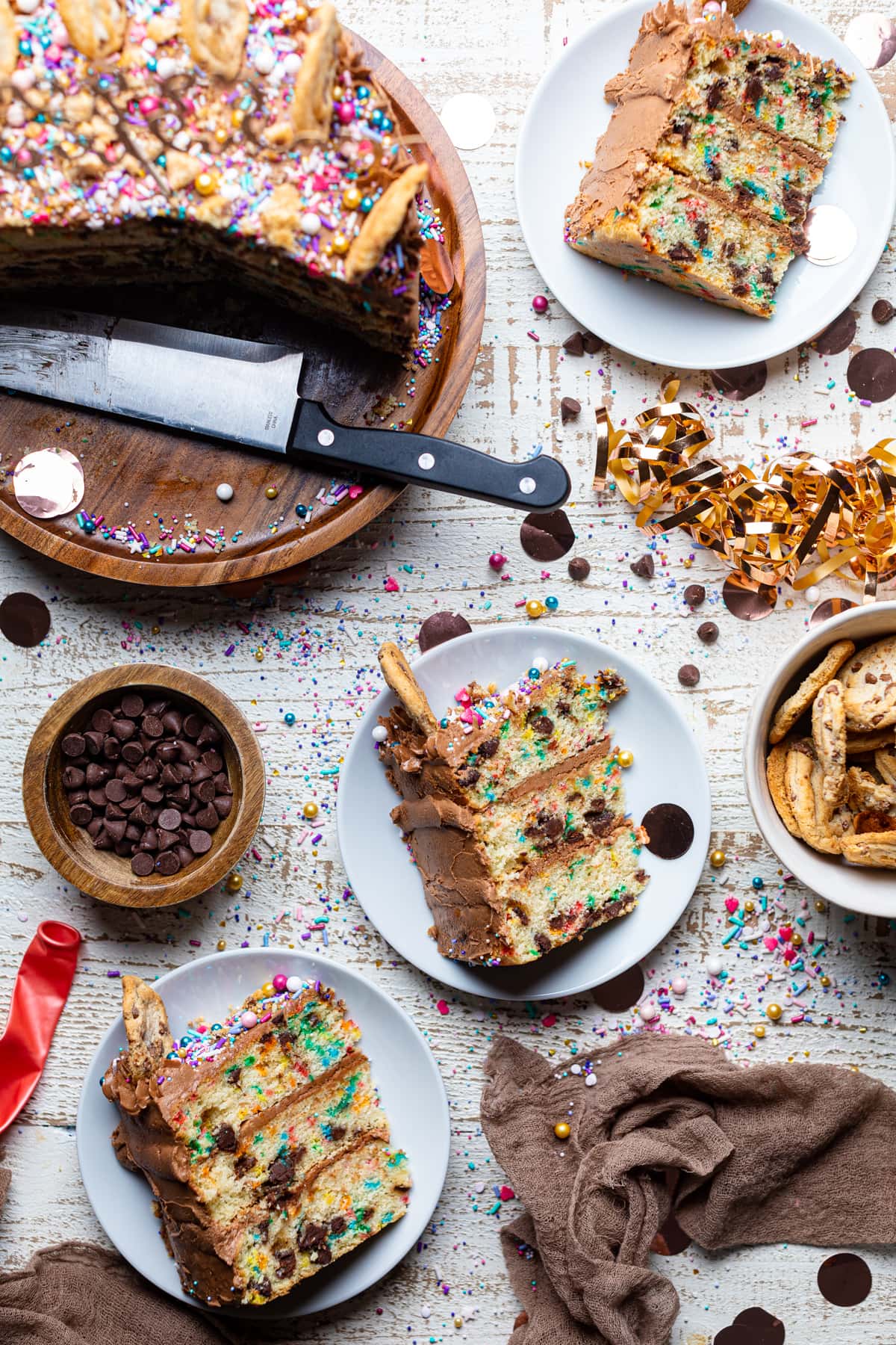 Slices of Confetti Chocolate Chip Cake on a table with sweets.