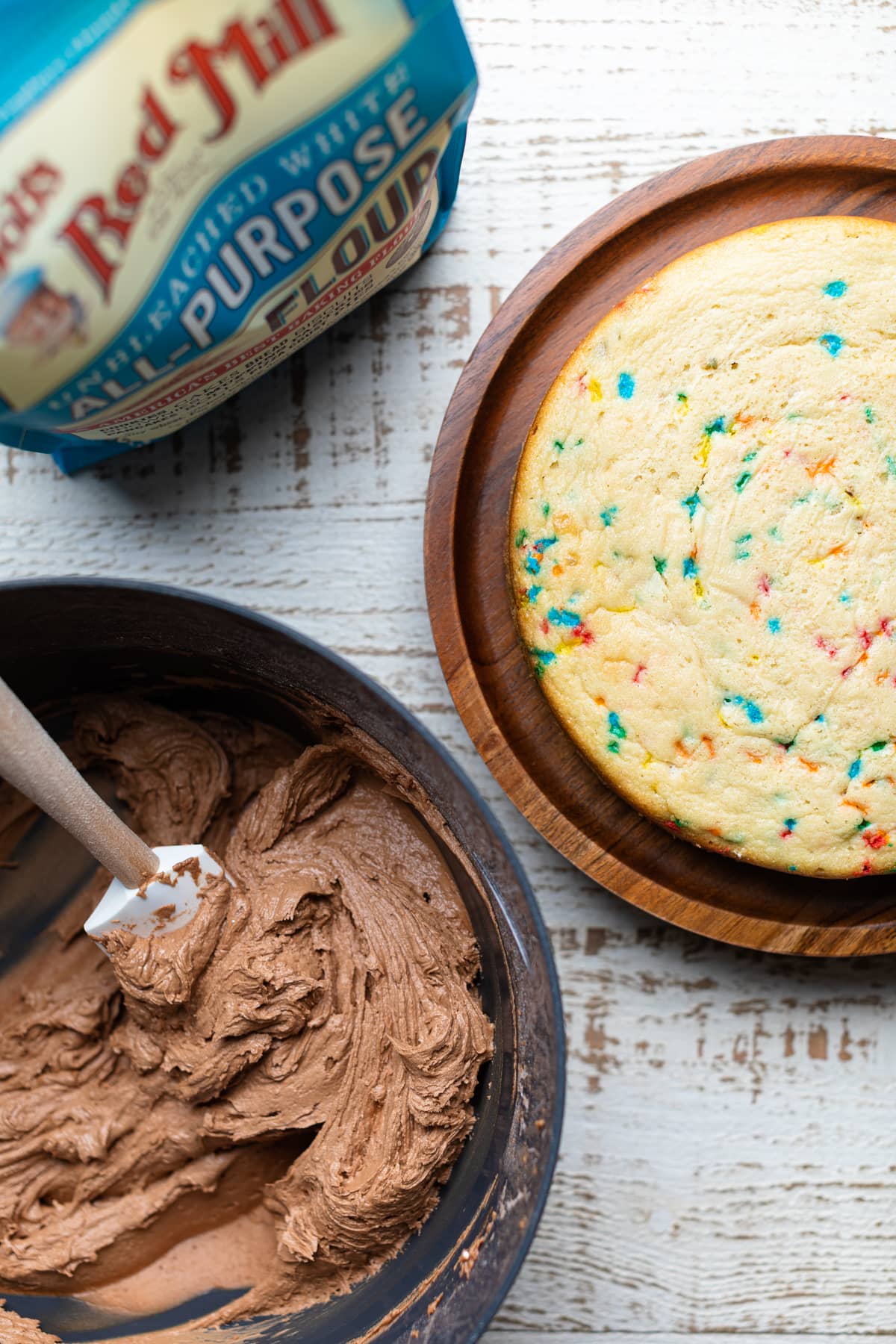 Confetti Chocolate Chip Cake next to a bowl of chocolate frosting.