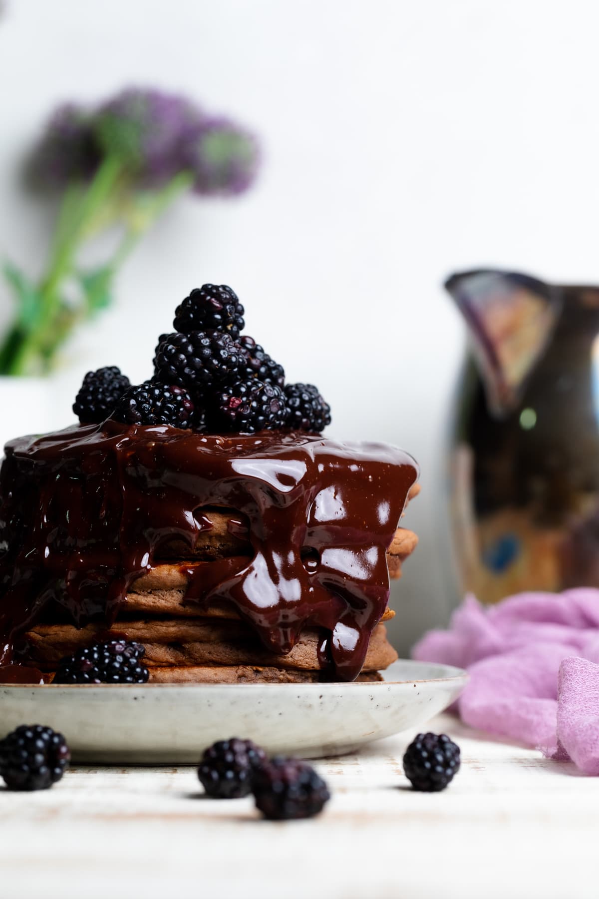 Vegan Chocolate Pancakes topped with Blackberries and drizzled chocolate.