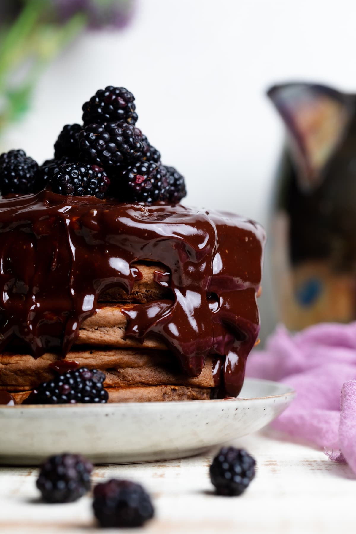 Vegan Chocolate Pancakes with Blackberries on a white plate.