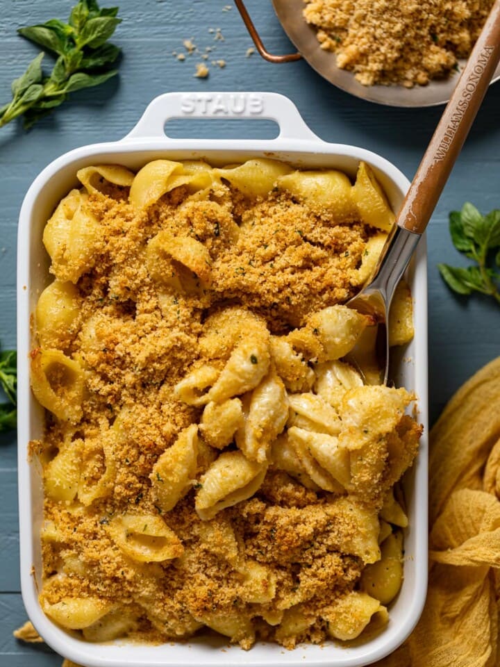 Spoon scooping some Southern Baked Mac and Cheese with Breadcrumbs out of a baking pan