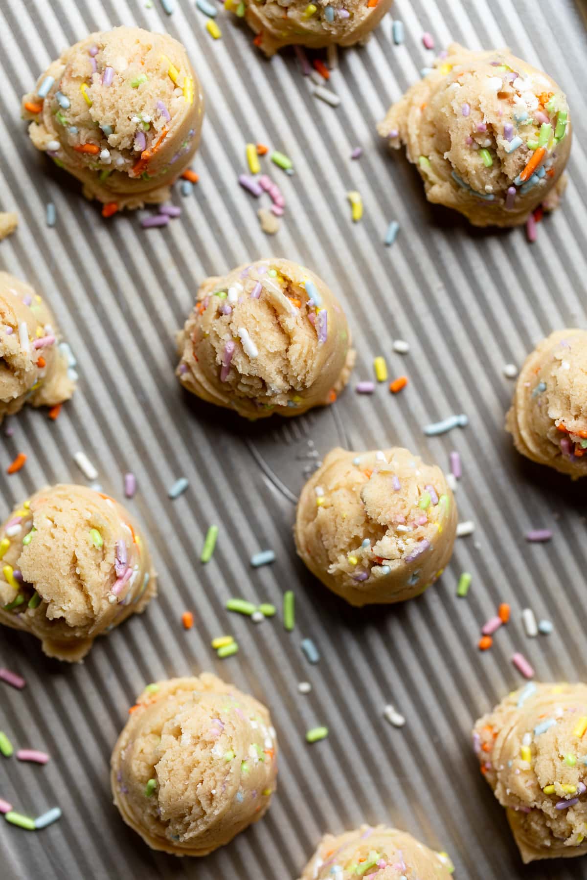 Scoops of Edible Vegan Funfetti Cookie Dough on a baking sheet.