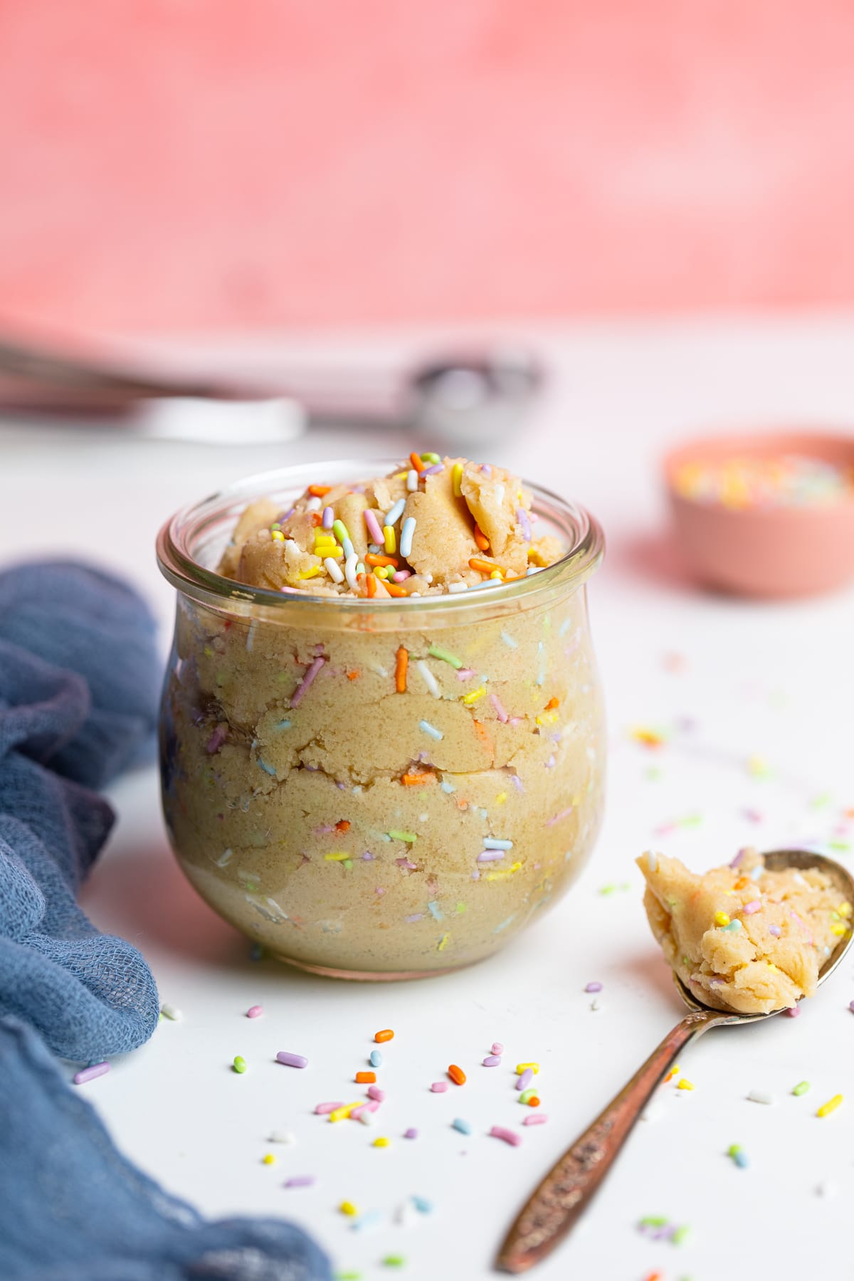 Spoon and glass of Edible Vegan Funfetti Cookie Dough.