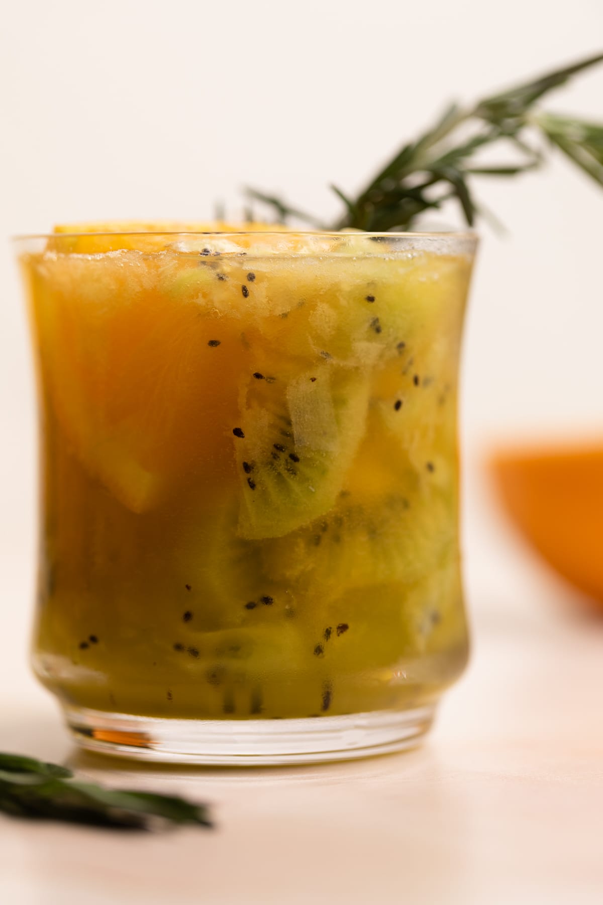 Orange Kiwi Ginger Mocktail garnished with rosemary.