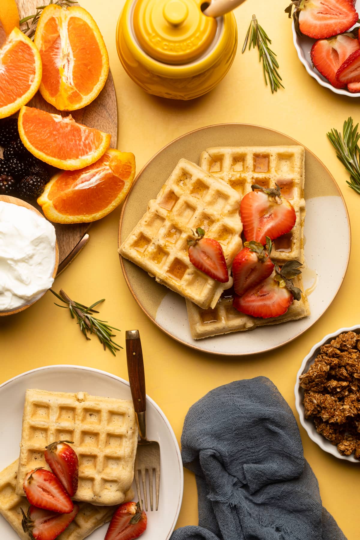 Gluten-Free Lemon Poppyseed Waffles topped with strawberries on a plate.