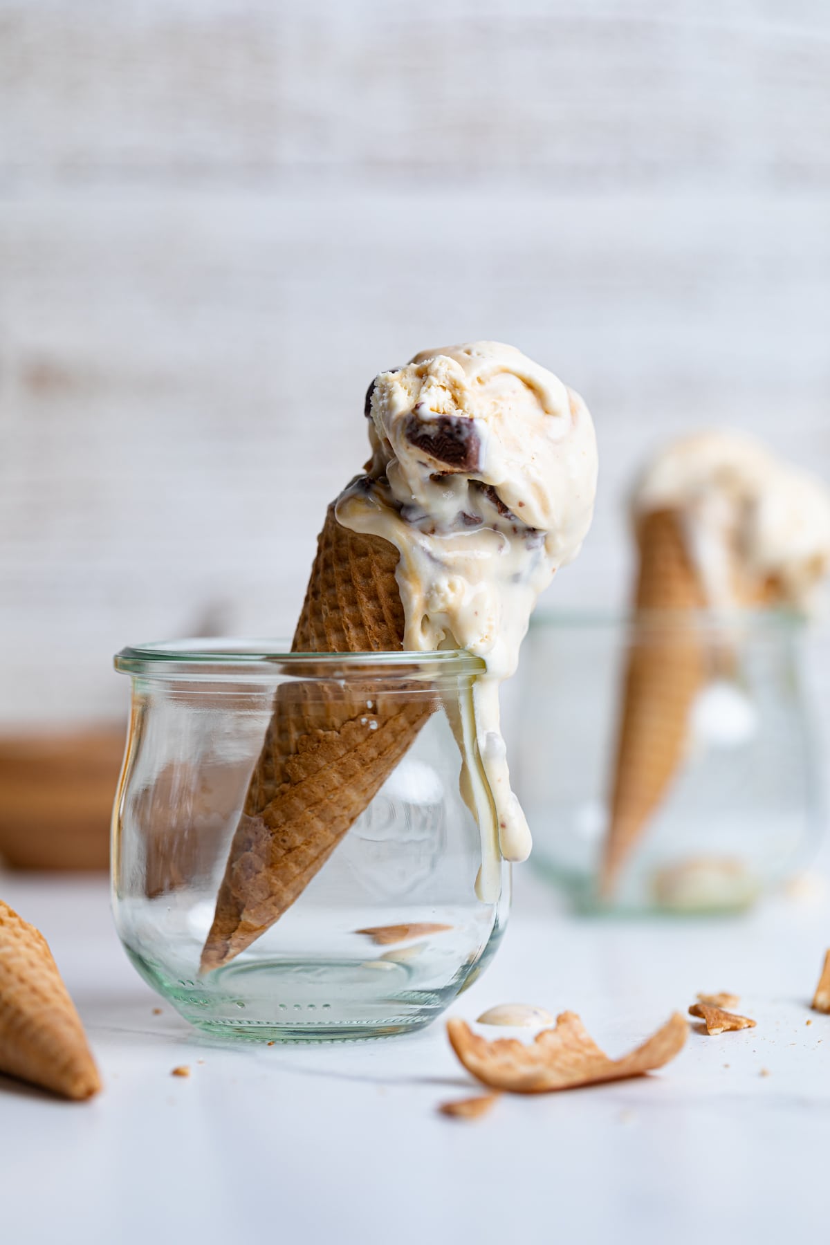 Glass jars holding Loaded No-Churn Snickers Ice Cream cones.