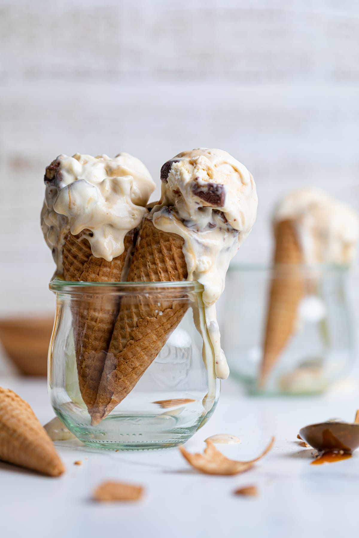 Two Loaded No-Churn Snickers Ice Cream cones in a glass jar.