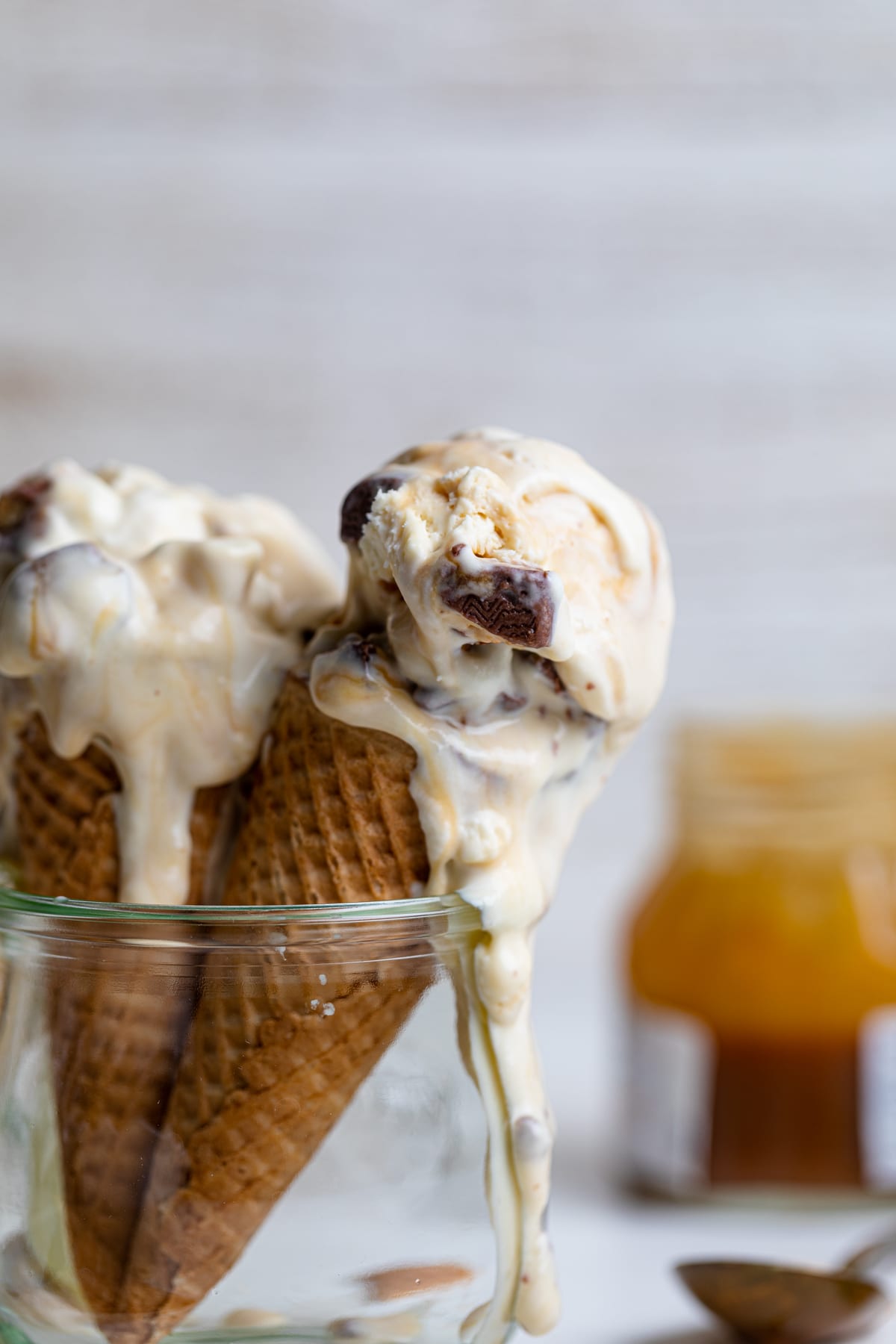 Two Loaded No-Churn Snickers Ice Cream cones in a glass jar.