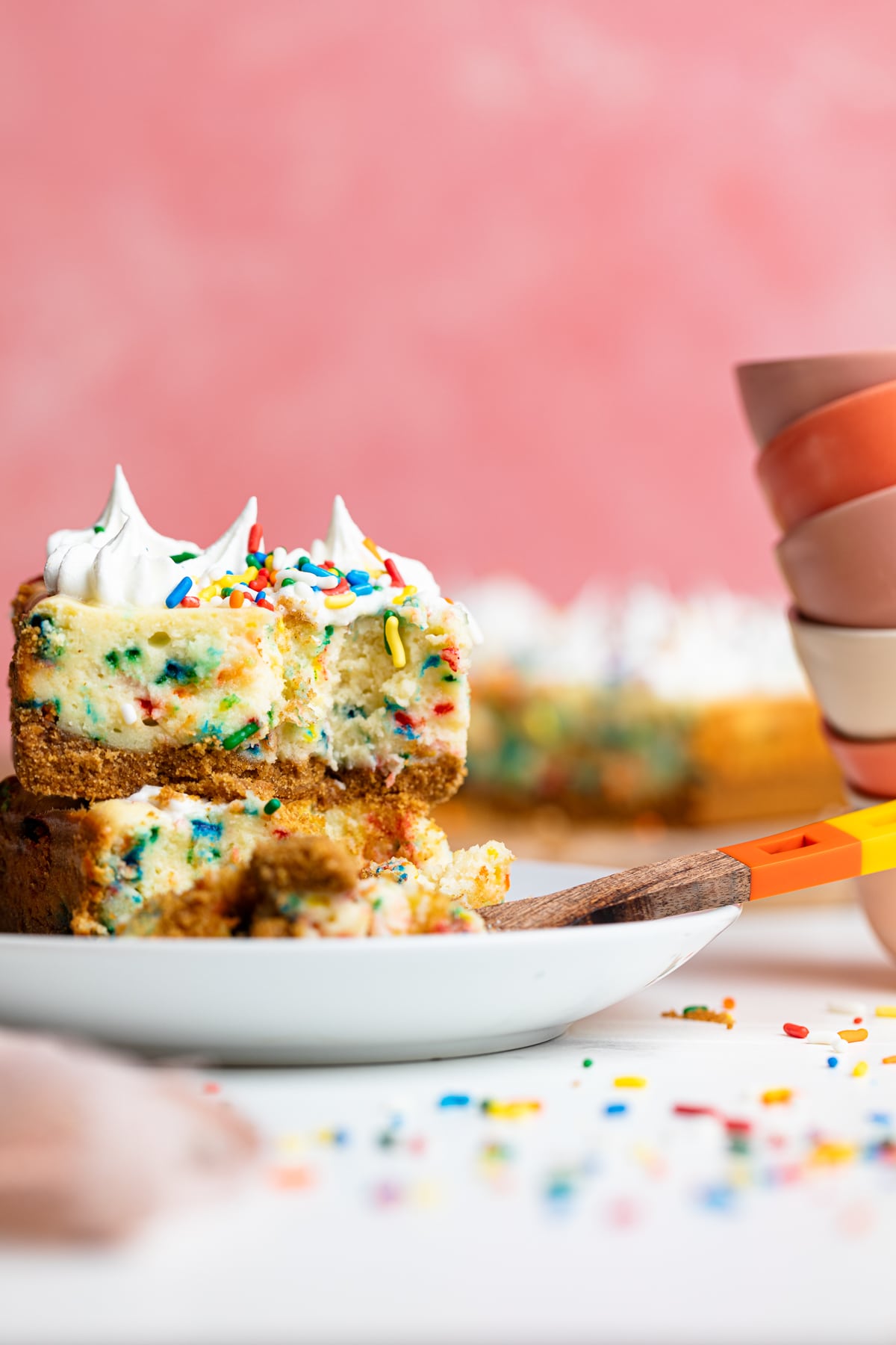 Stacked Funfetti Cheesecake Bars missing a bite.