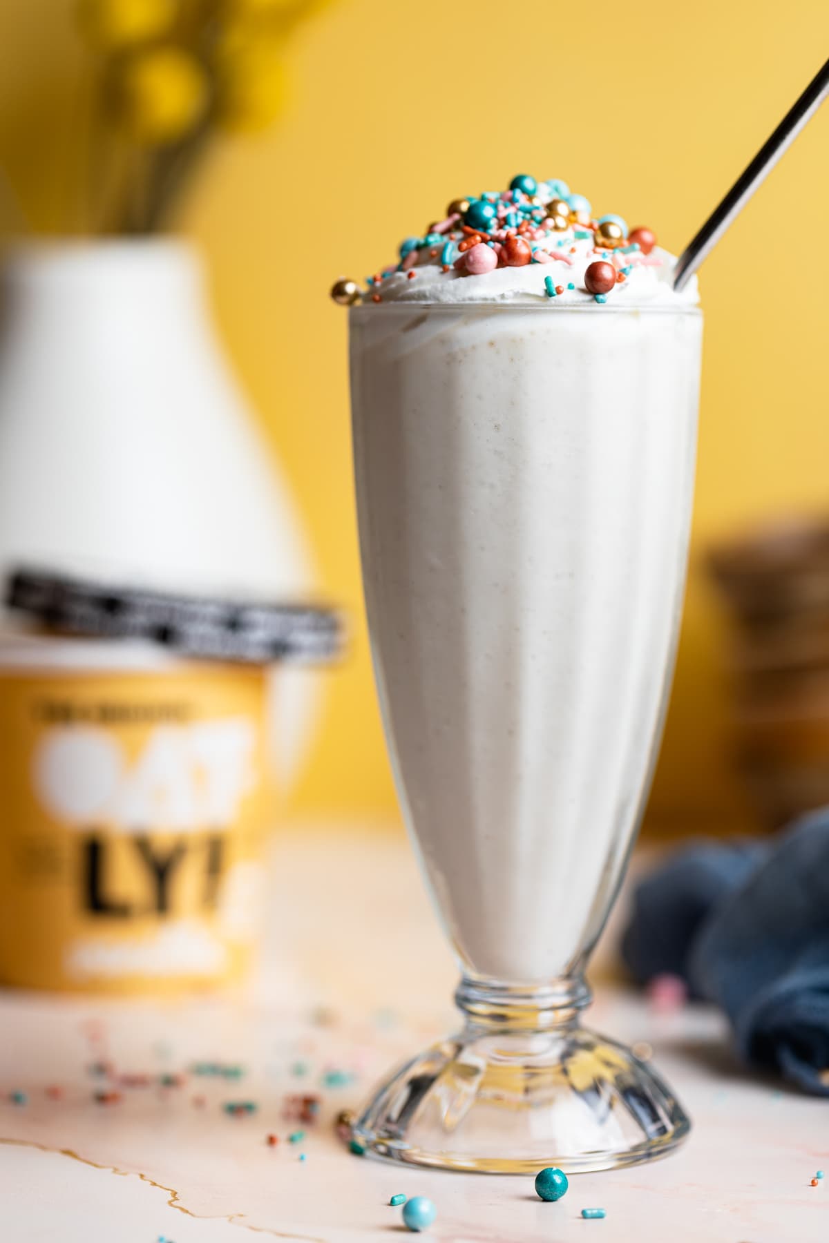 Tall glass of Dairy-Free Vanilla Funfetti Milkshake topped with sprinkles.