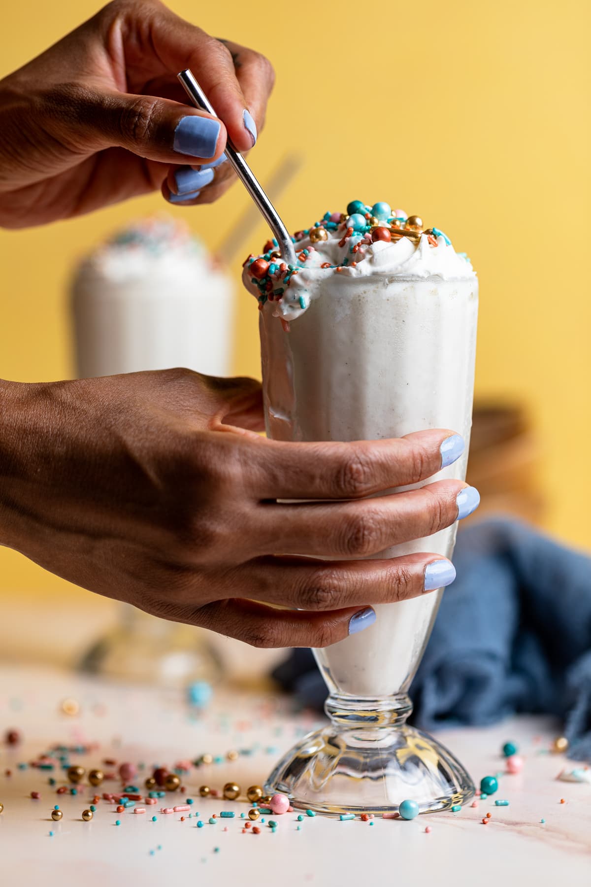 Woman grabbing a Dairy-Free Vanilla Funfetti Milkshake.