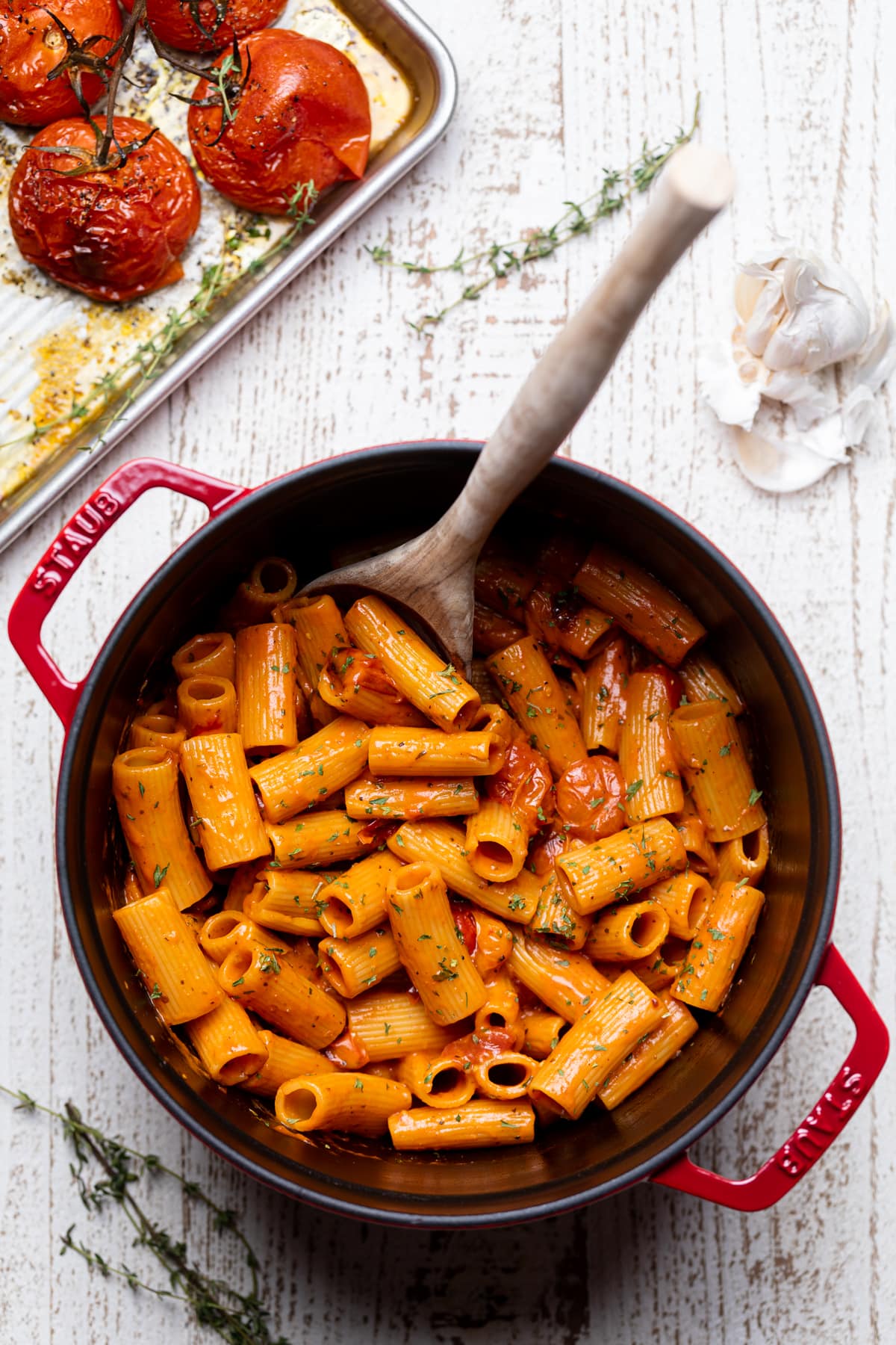 Wooden spoon stirring a Dutch oven of Spicy Cajun Vodka Pasta without Vodka.