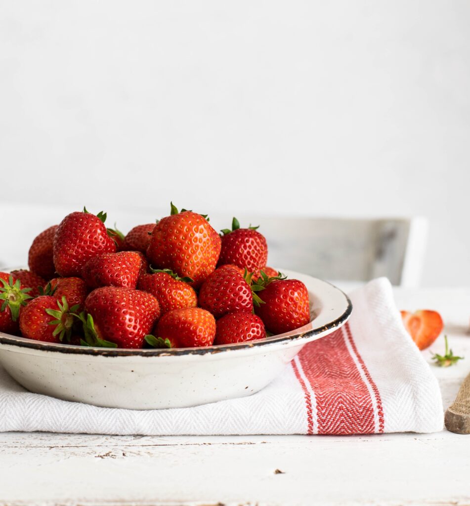 Bowl of strawberries on a cloth napkin.