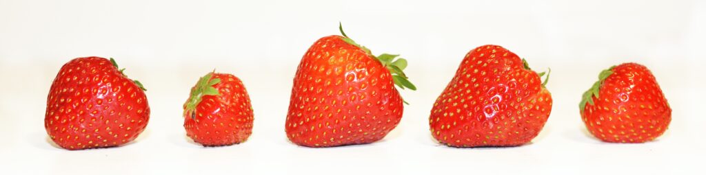 Bright red strawberry on a white surface.